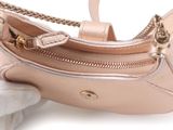 someone is holding a pink purse with a gold chain on it