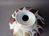 a brown and white vase sitting on a table