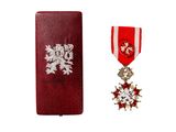 une image représentant un écrin rouge orné d'une médaille en argent et d'un ruban rouge