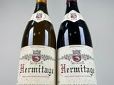 two bottles of wine sitting next to each other on a table