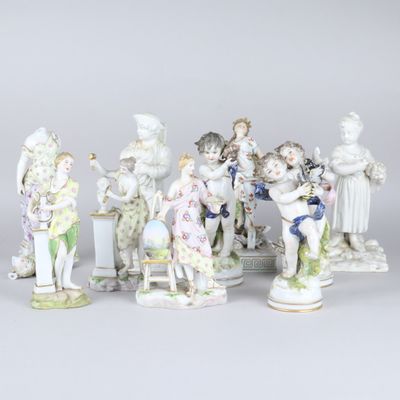 Plusieurs figurines en porcelaine, de tailles et de formes variées, sont exposées sur une table