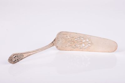 une cuillère ancienne en argent, avec un manche, posée sur une surface blanche