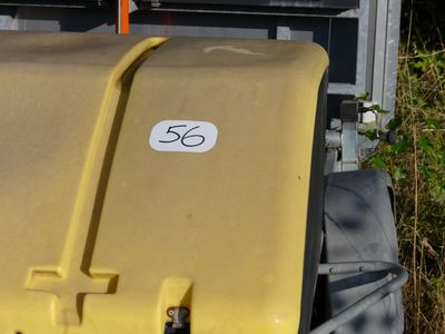 a yellow trash can sitting in front of a building