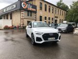 the audi q4 is parked in front of a building in a parking lot