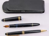 two fountain pens and a pen case on a white surface