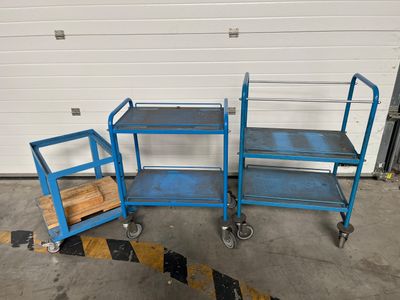 Trois chariots bleus sont garés devant la porte d'un garage.