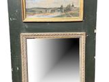 an old wooden mirror with a painting hanging on it ' s side