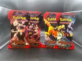Deux paquets de cartes à collectionner Pokémon sont posés sur une table.