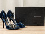 blue high heel shoes and a black box on a wooden table