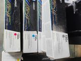 three boxes of ink sitting on top of a table next to a printer