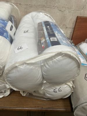 a pile of white pillows and blankets on a table