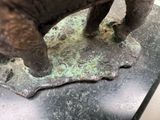 a statue of an elephant that is standing on a piece of metal