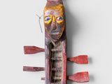 wooden sculpture of a man in a boat with oars on a white surface
