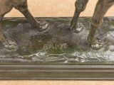 a bronze statue of a horse and a dog on a table