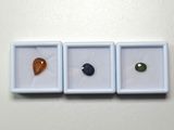 trois pierres de couleurs différentes posées dans une boîte blanche
