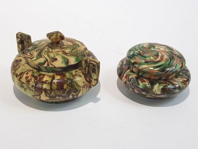 deux petits objets en céramique posés l'un à côté de l'autre sur une surface blanche