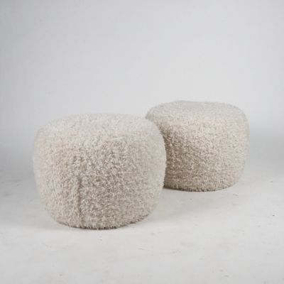 pair of white wool poufts on a white background