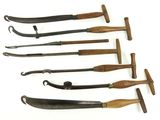 several different types of knives are lined up on a white surface