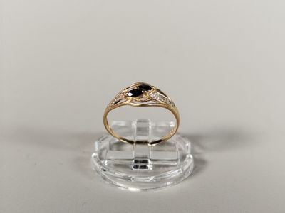 a close up of a gold ring with a black stone on it