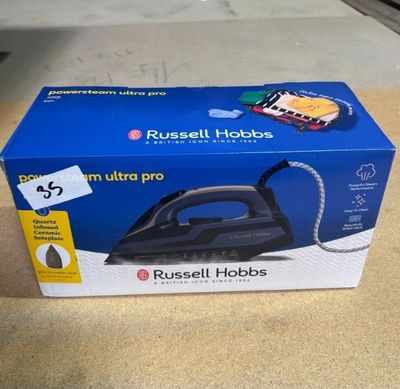 une boîte contenant un fer à repasser à vapeur Ultra Pro de Russell Hobbs posée sur une table