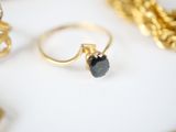 a gold ring with a black stone sitting on top of it