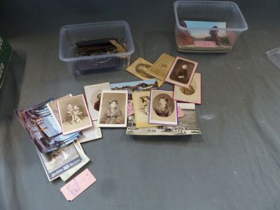 beaucoup de vieilles photos posées sur une table, à côté de bacs en plastique