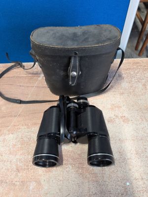 une vieille paire de jumelles posée sur une table en bois