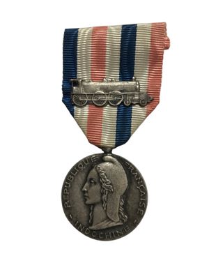 une vieille médaille en argent ornée d'un ruban rouge, blanc et bleu