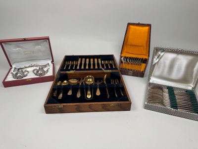 plusieurs types d'argenterie dans un coffret en bois posé sur une surface blanche