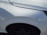 a close up of a white car with water on it