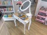 a white vanity table with a mirror on top of it