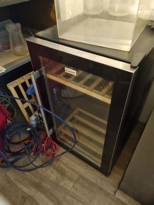 a small refrigerator with a wine cooler inside of it