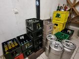 many beer kegs and crates in the corner of a room