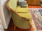 a green chair in the corner of a room next to a radiator