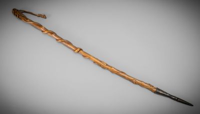 an old cane with a wooden handle on a gray background