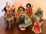 many figurines of people sitting on a wooden table