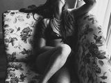 a black and white photo of a woman sitting on a couch