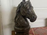 a statue of a horse head sitting on a wooden table