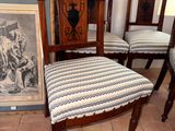 four chairs that are sitting in front of a picture