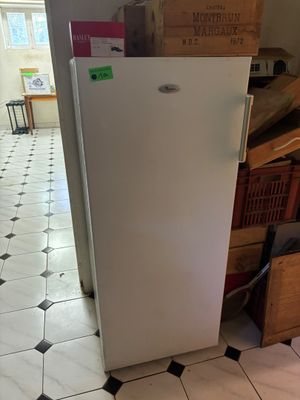 une photo d'un réfrigérateur dans une cuisine où il y a beaucoup de cartons par terre