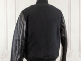 black leather jacket on a mannequin stand in front of a white wall
