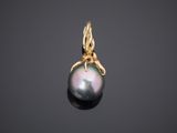a black pearl and gold pendant on a black background