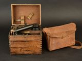 an old wooden box with a telescope and other items in it