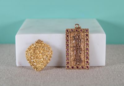 deux pendentifs en or et rubis dans un coffret blanc