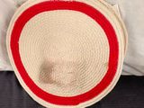 un chapeau de paille posé sur un oreiller, sur un lit