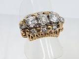 a close up of a gold and diamond ring on a white surface