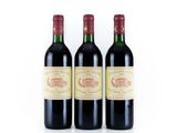 trois bouteilles de vin rouge posées l'une à côté de l'autre sur une surface blanche