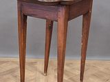 a small wooden table with a leather top on a parquet floor