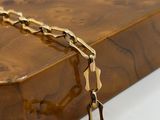 chunk of wood with a gold chain on a white background