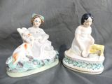 two figurines of a woman and a child sitting on a boat